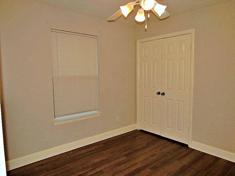 313 Timbercreek Court, Princeton, TX 75407 Neutral-toned interior featuring wood-finish flooring, a single-hung window with built-in blinds, double-panel closet doors, and a multi-light ceiling fixture