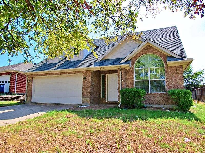 313 Timbercreek Court, Princeton, TX 75407 Brick exterior featuring a gabled roofline, arched window, and two-car garage