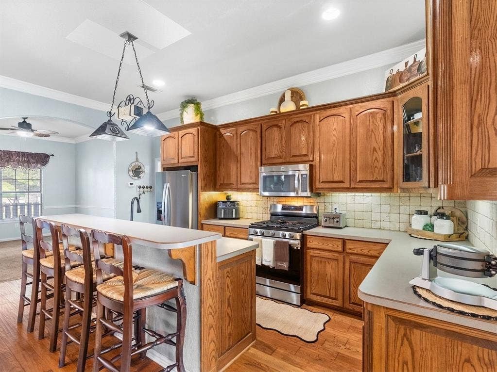 3103 Rim Rock Court, Granbury, TX 76049 Kitchen has stainless appliances and warm wood cabinets