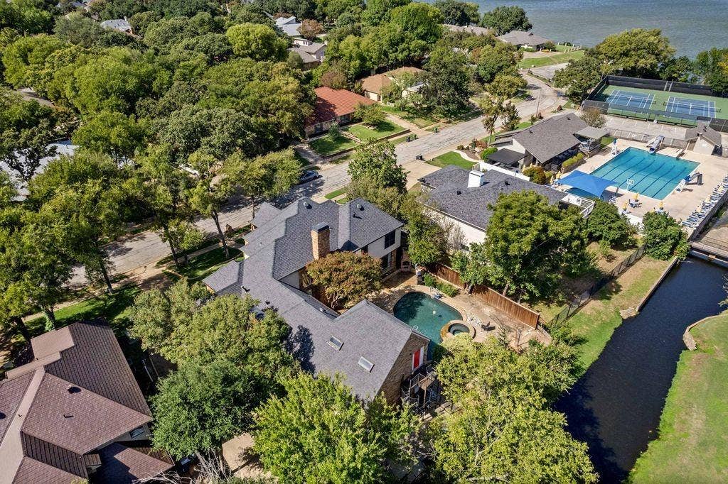 Aerial perspective featuring a multi-gabled roofline, private swimming pool, integrated spa, and skylights