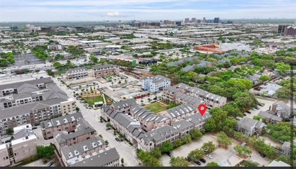 Aerial perspective showcasing a residential community with multi-story townhomes and mature trees