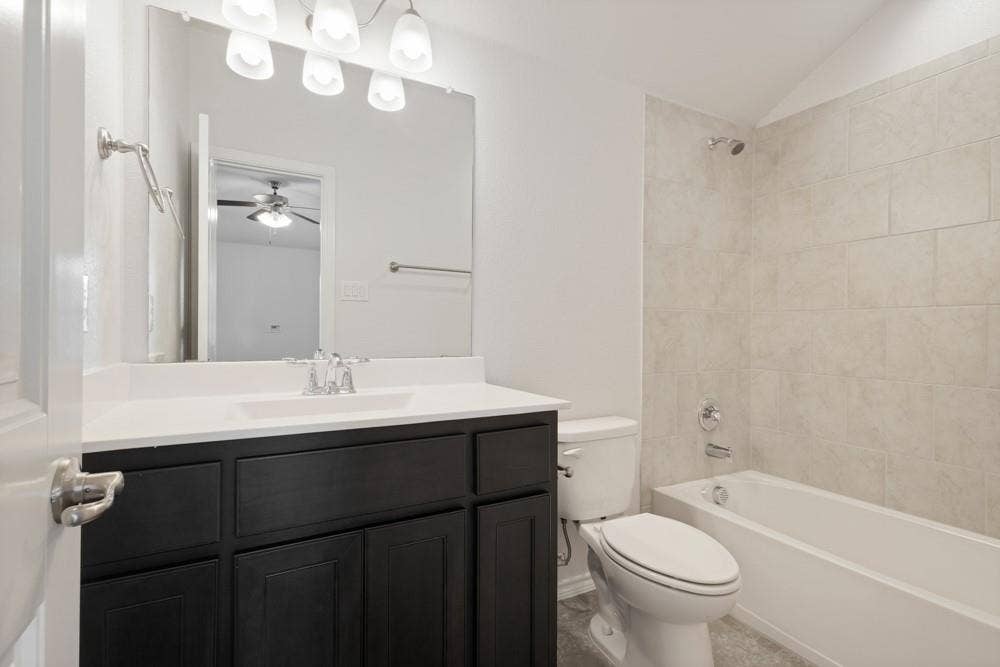 Dark-finish vanity cabinetry with a white countertop and integrated sink, full-width mirror, polished chrome plumbing fixtures, and tile-surround tub