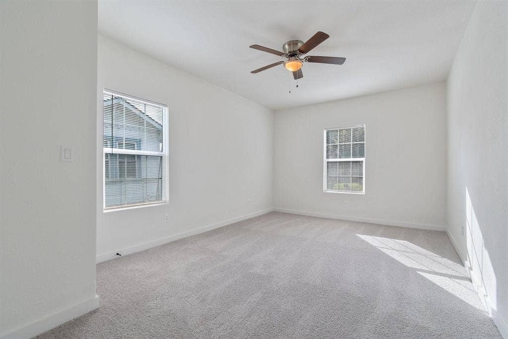 3023 Spurlock Street, Dallas, TX 75223 Neutral interior space featuring wall-to-wall carpeting, dual windows, and a central ceiling fan with integrated lighting