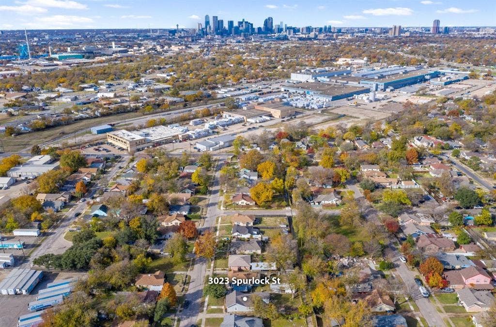 3023 Spurlock Street, Dallas, TX 75223 Aerial perspective of 3023 Spurlock St featuring a residential neighborhood setting with prominent city skyline backdrops and mature trees