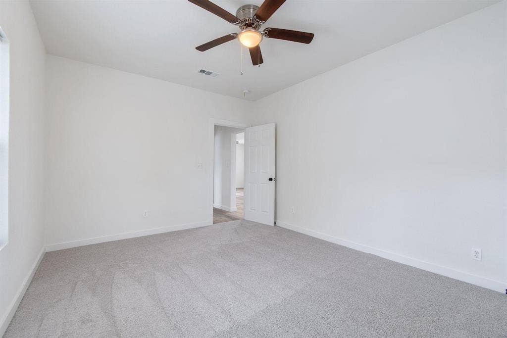 3023 Spurlock Street, Dallas, TX 75223 Neutral-toned carpeting, white walls, and a brushed metal ceiling fan with integrated light fixture