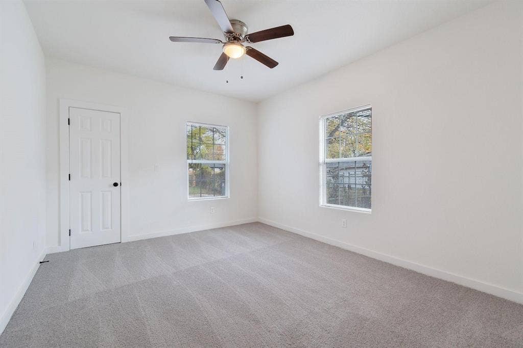 3023 Spurlock Street, Dallas, TX 75223 Neutral-toned wall-to-wall carpeting, dual windows, a ceiling fan with integrated lighting, and a solid-core interior door