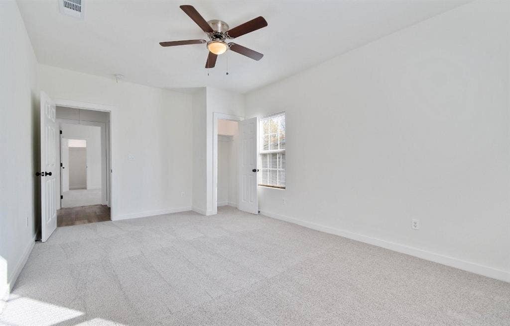 3023 Spurlock Street, Dallas, TX 75223 Neutral-toned carpeting, ceiling fan with integrated light fixture, and interior doors
