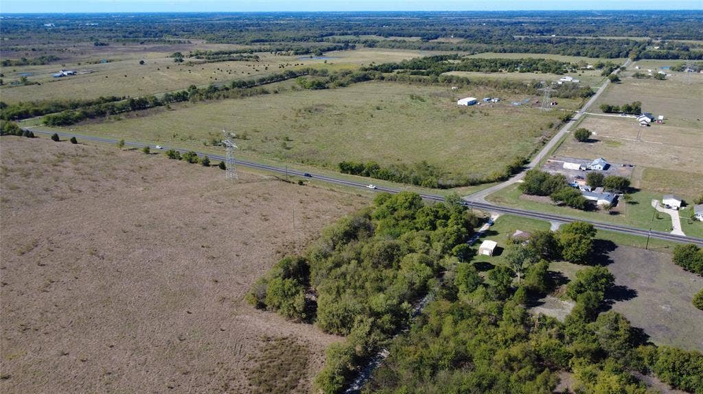 147 Private Road 4330, Greenville, TX 75401 Expansive acreage featuring cleared pastureland, mature tree clusters, and paved road frontage