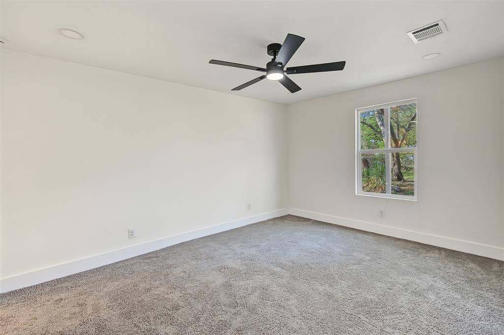 Neutral interior featuring plush wall-to-wall carpeting, recessed lighting, and a modern black ceiling fan with an integrated light fixture