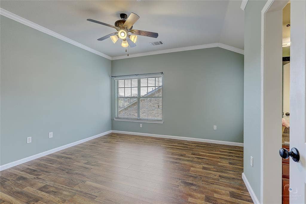 Vaulted ceilings, wood-finish flooring, ceiling fan with integrated lighting, and multi-pane window