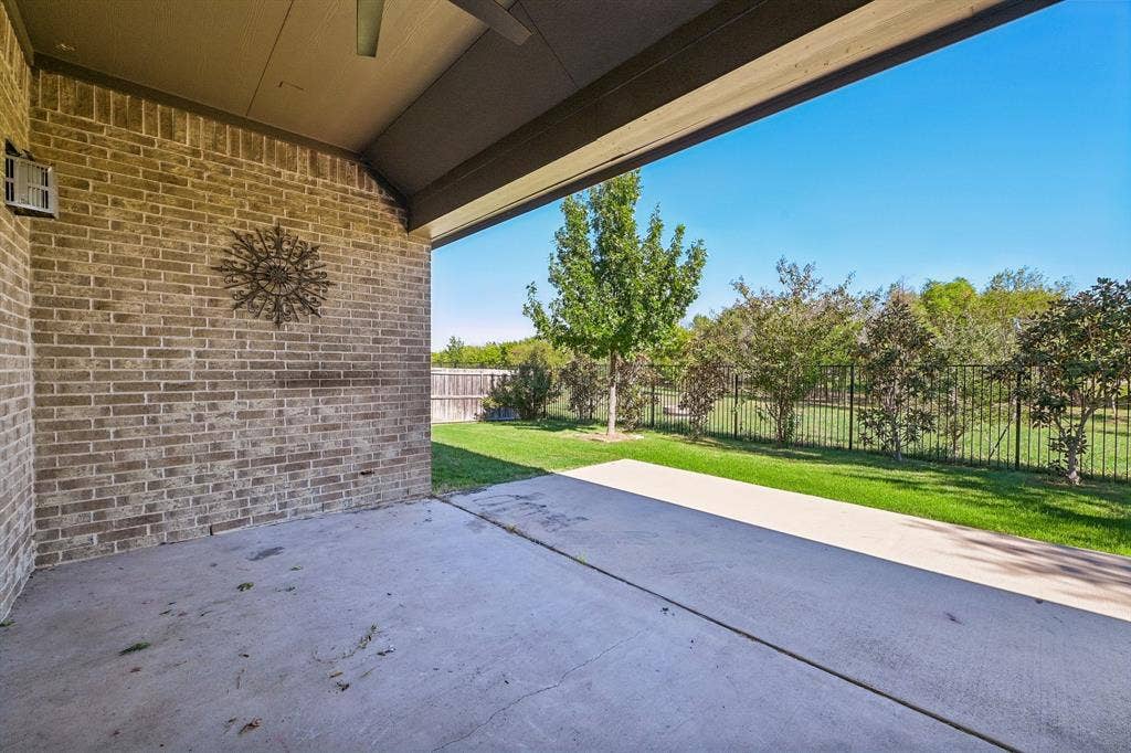 284 Goliad Trail, Forney, TX 75126 Covered brick patio featuring a concrete floor, recessed ceiling lighting, and a metal perimeter fence enclosing the backyard