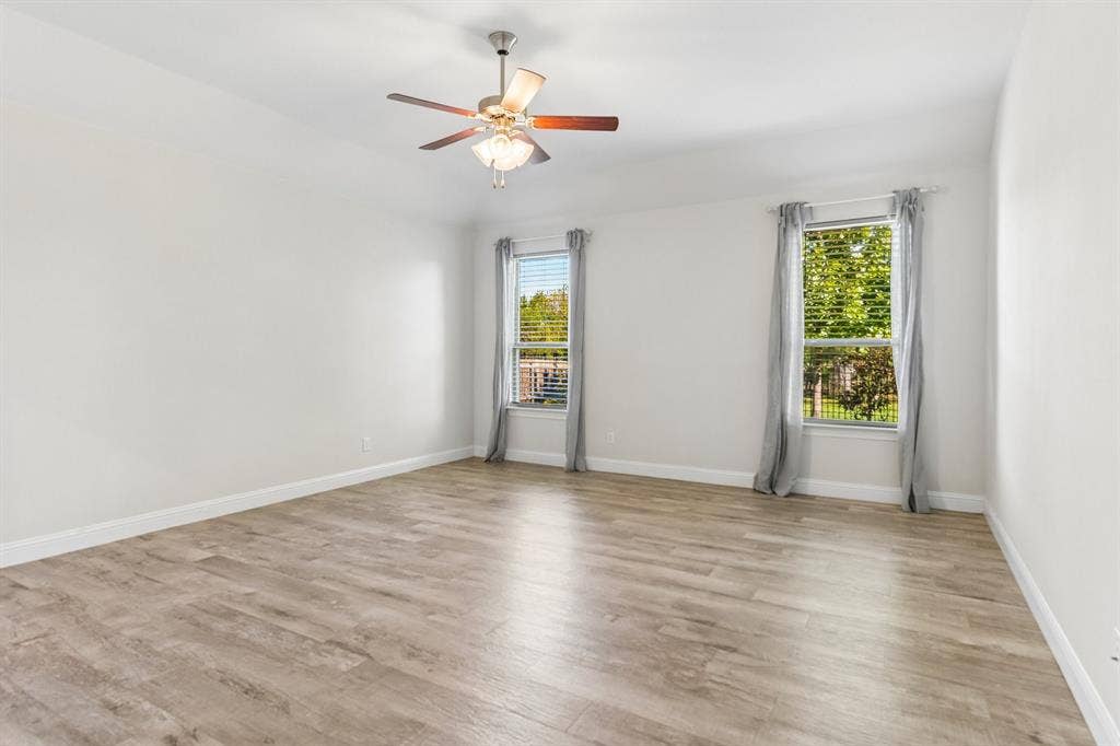 284 Goliad Trail, Forney, TX 75126 Spacious room featuring wood-finish flooring, dual windows, and a ceiling fan with integrated lighting