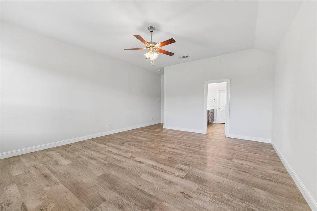 284 Goliad Trail, Forney, TX 75126 Vaulted ceilings featuring a centrally mounted ceiling fan with integrated lighting and neutral wood-finish flooring