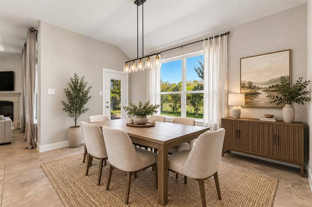284 Goliad Trail, Forney, TX 75126 Dining space featuring vaulted ceilings, large multi-pane windows, a five-light linear pendant fixture, and neutral stone-finish flooring