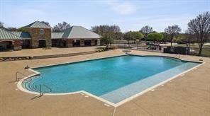 284 Goliad Trail, Forney, TX 75126 Rectangular swimming pool with built-in stairs, surrounded by a paved patio area and masonry building structure