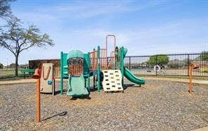 284 Goliad Trail, Forney, TX 75126 Playground structure featuring a slide, climbing wall, and metal safety fencing