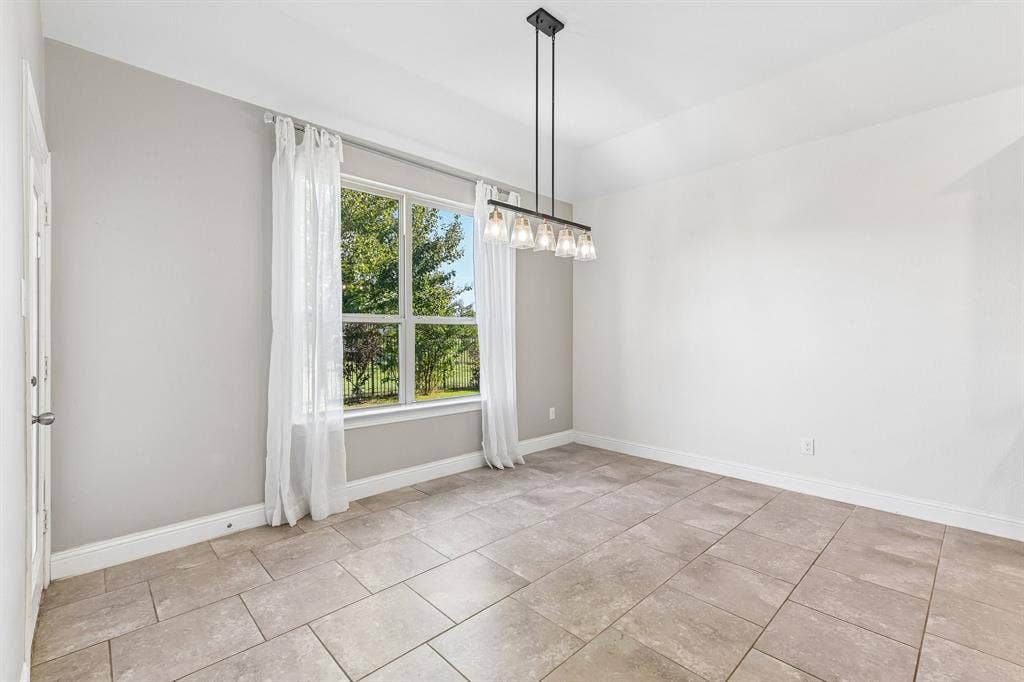 284 Goliad Trail, Forney, TX 75126 Room featuring large-format ceramic tile flooring, neutral wall paint, a multi-light linear chandelier, and a substantial window