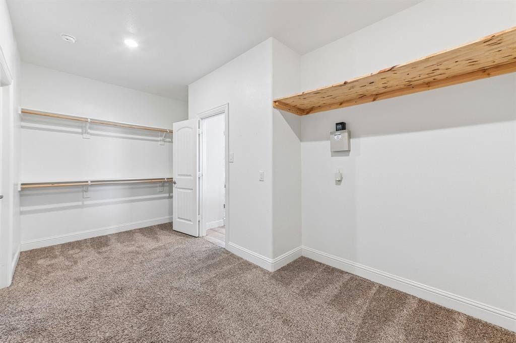 284 Goliad Trail, Forney, TX 75126 Walk-in storage space featuring neutral carpeting, white interior walls, and tiered natural-wood shelving
