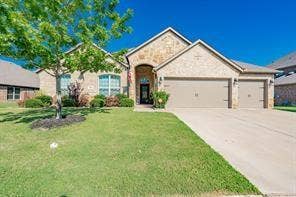 284 Goliad Trail, Forney, TX 75126 Brick and stone facade exterior featuring a covered entryway, multi-gabled roofline, and a three-car garage