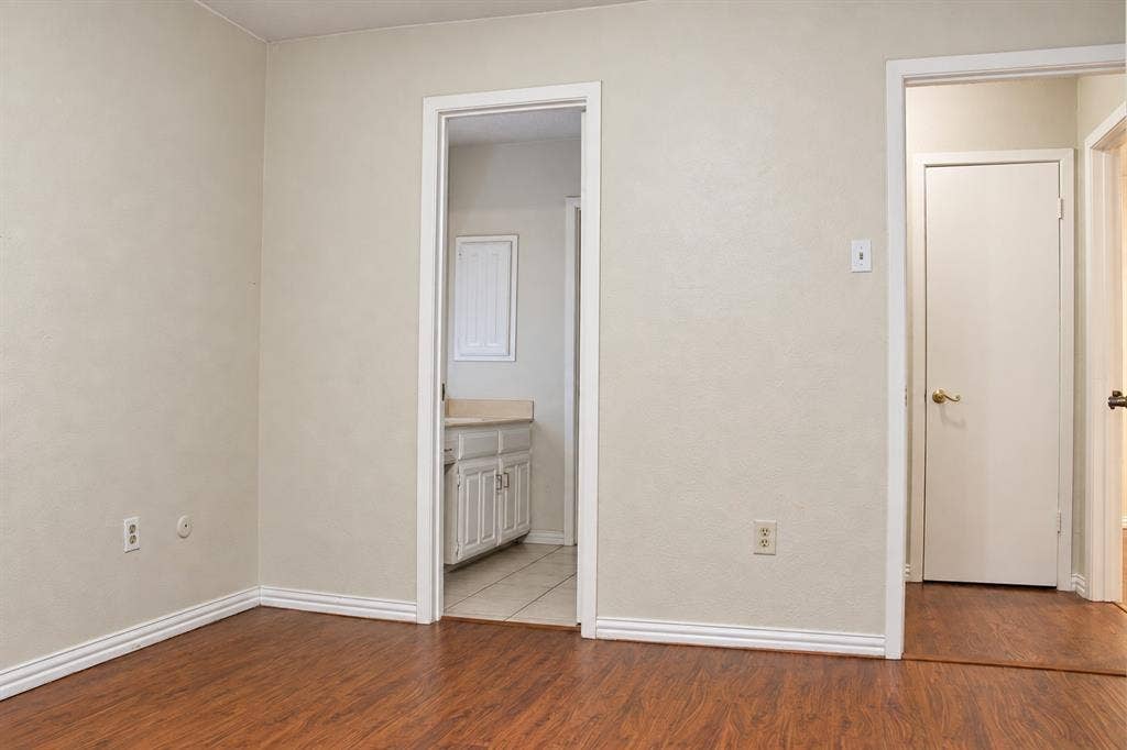 895 Dublin Drive, #4, Richardson, TX 75080 Wood-finish flooring, neutral wall tones, multi-panel interior doors, and custom-finish vanity cabinetry