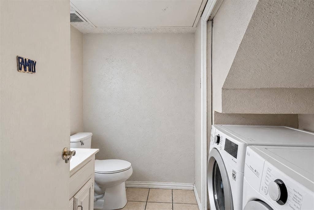 895 Dublin Drive, #4, Richardson, TX 75080 Full bathroom featuring tile flooring, a white vanity cabinet, a commode, and dedicated space for laundry appliances