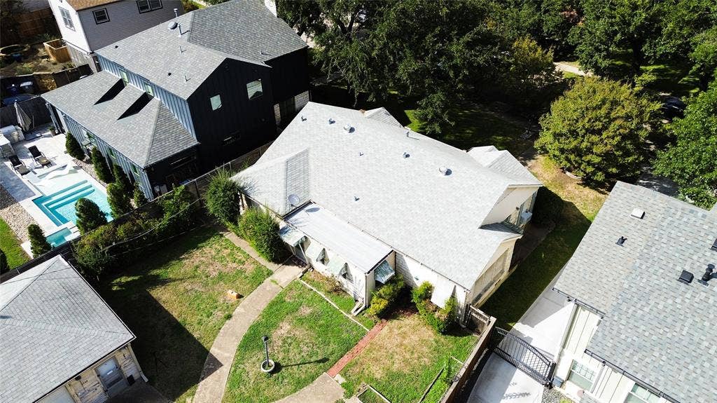 Aerial perspective of property lot featuring an expansive backyard, concrete paved pathway, and mature trees