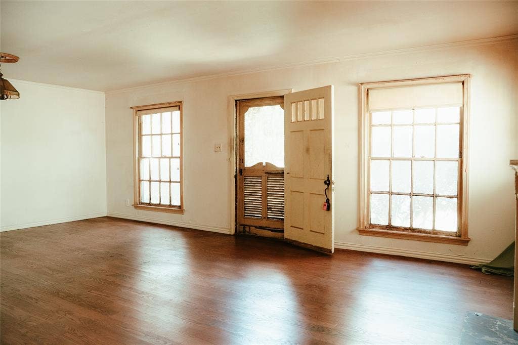 Interior space featuring wood-finish flooring, two multi-pane windows, and a paneled exterior door with inset glass