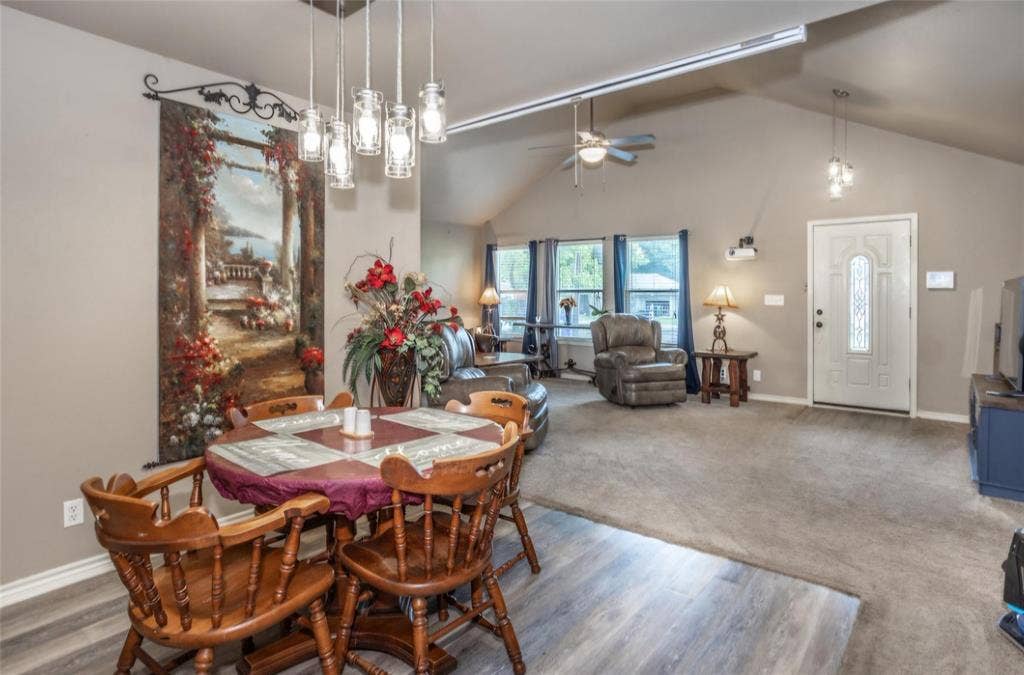Vaulted ceilings featuring a multi-pendant glass light fixture and a ceiling fan