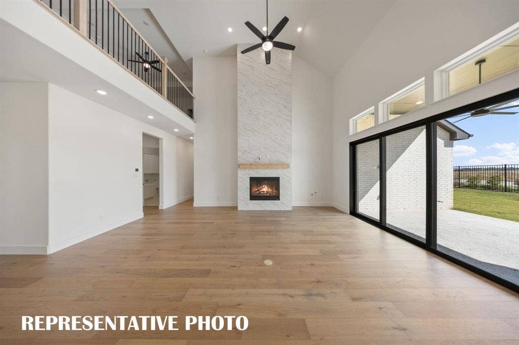 Featuring soaring ceilings, a cozy fire place and full wall slider, this family room is the ideal space for the family to gather.  REPRESENTATIVE PHOTO