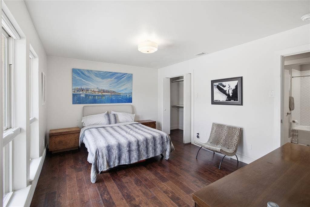 Another perspective of the primary bedroom showcases its generous proportions, comfortable layout, and additional space for furnishings. The view toward the hallway helps illustrate the bedroom's connection to the rest of the home.
