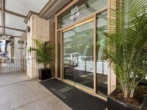 500 Throckmorton Street, #2702, Fort Worth, TX 76102 Building entrance featuring glass-paneled double doors, metal framing, a covered exterior walkway, and stone-finished structural pillars