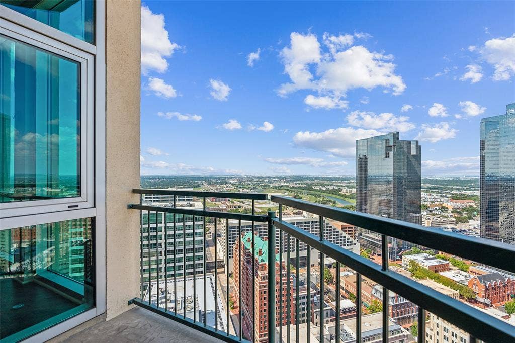 500 Throckmorton Street, #2702, Fort Worth, TX 76102 Private balcony with metal railing, floor-to-ceiling glass windows, and panoramic urban cityscape