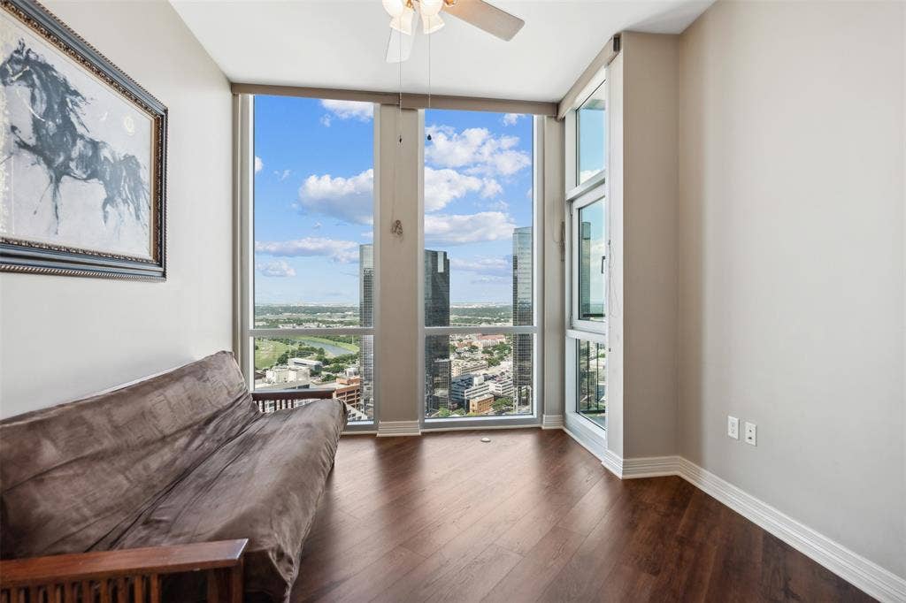 500 Throckmorton Street, #2702, Fort Worth, TX 76102 Floor-to-ceiling windows featuring urban landscape scenery, wood-finish flooring, and a ceiling-mounted light fixture