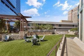 500 Throckmorton Street, #2702, Fort Worth, TX 76102 Elevated terrace featuring a manicured lawn, a stone-clad fire pit, a structural timber-frame pergola, and metal safety railings