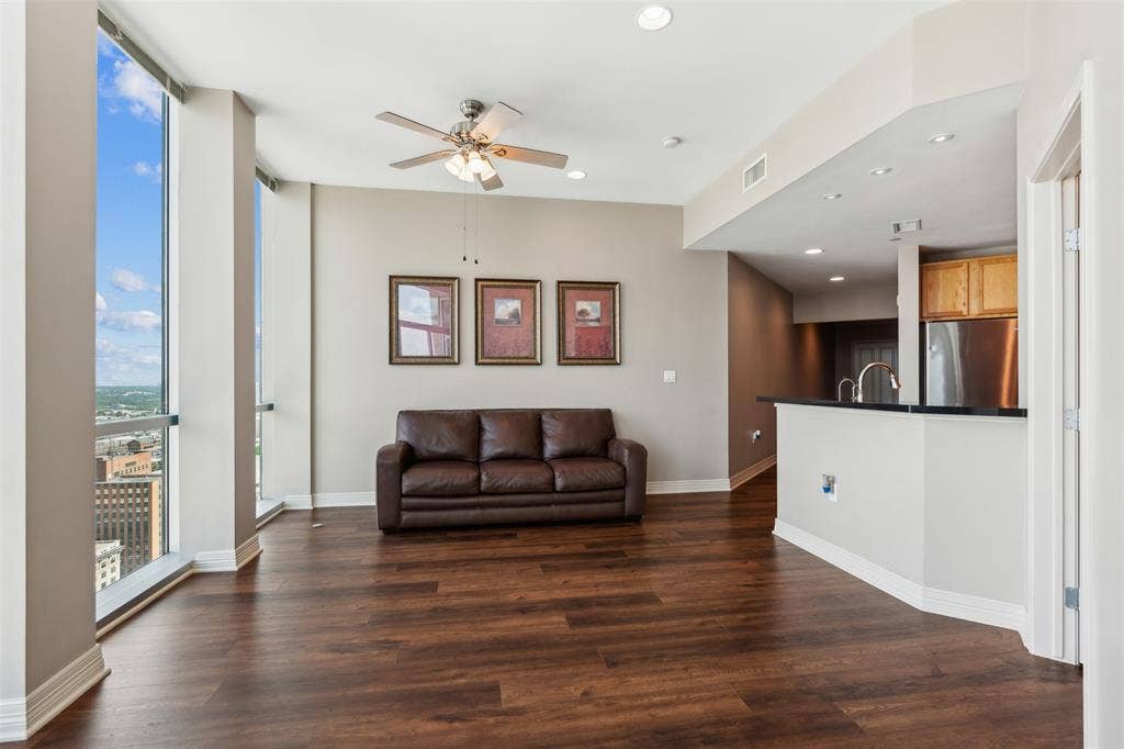 500 Throckmorton Street, #2702, Fort Worth, TX 76102 Floor-to-ceiling windows, wood-finish flooring, recessed lighting, ceiling fan, and kitchen peninsula with a dark countertop