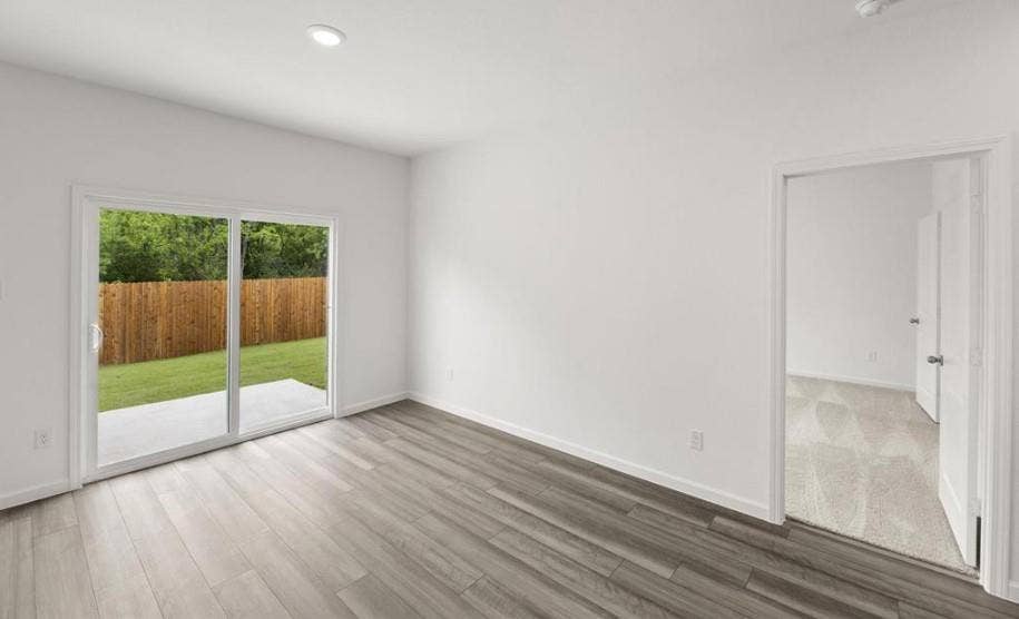 Interior room featuring wood-finish flooring, recessed lighting, and a glass sliding door