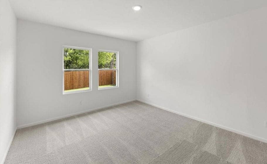 Neutral interior space featuring carpeted flooring, two double-pane windows, and recessed ceiling lighting