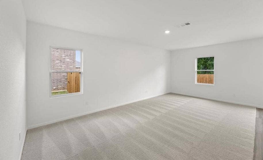 Neutral-toned wall-to-wall carpeting, crisp white wall finishes, and recessed lighting