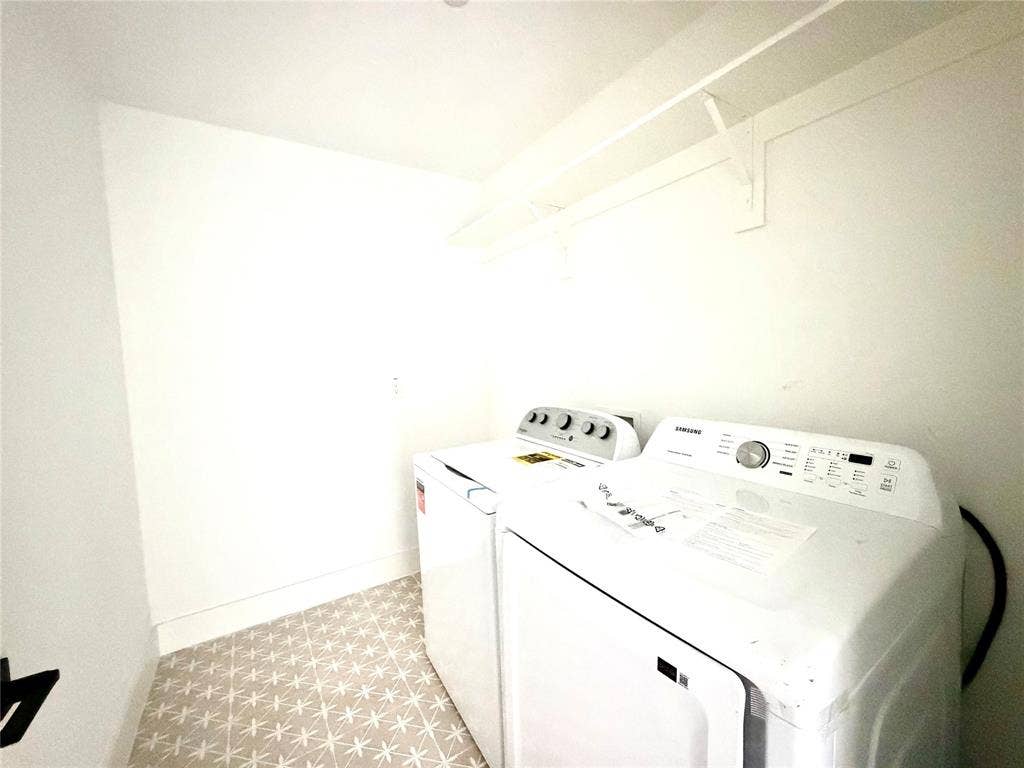 8902 Lowell Street, Rowlett, TX 75089 Utility space featuring patterned tile flooring and built-in white overhead shelving with a mounted hanging rod