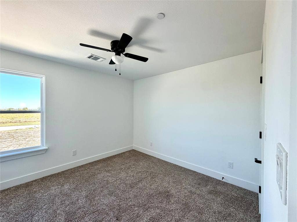 8902 Lowell Street, Rowlett, TX 75089 Neutral-toned carpeted flooring, white walls, and a black ceiling-mounted fan with integrated light fixture