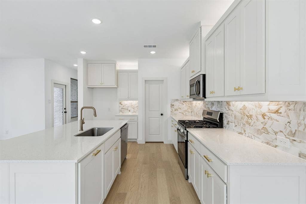 621 Taylor Parkway, Celina, TX 75009 Beautiful cabinetry, gorgeous counter tops and striking backsplash effortlessly pair with contemporary stainless steel to create a kitchen for the ages! REPRESENTATIVE PHOTO