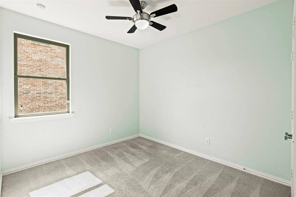 2305 Switchgrass Street, Melissa, TX 75454 Neutral-toned wall paint, wall-to-wall carpeting, brushed-nickel ceiling fan with integrated lighting, and a single-hung window featuring a masonry exterior