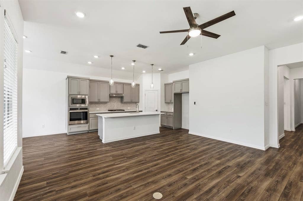 2305 Switchgrass Street, Melissa, TX 75454 Kitchen featuring wood-finish flooring, grey shaker-style cabinetry, white center island, built-in double oven, and recessed ceiling lighting