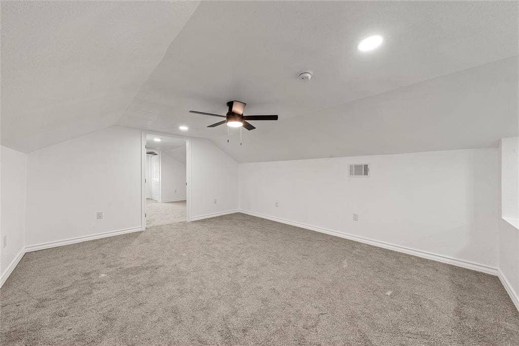 Sloped ceilings with recessed lighting, integrated ceiling fan, and wall-to-wall carpeting