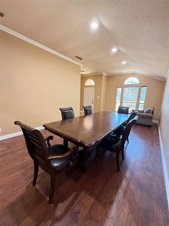 Vaulted ceilings, wood-finish flooring, recessed lighting, crown molding, and arched window detailing