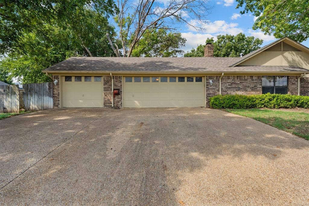 10 Oleander Street, Waco, TX 76708 Brick and siding exterior featuring a three-car garage, concrete driveway, and asphalt shingle roof