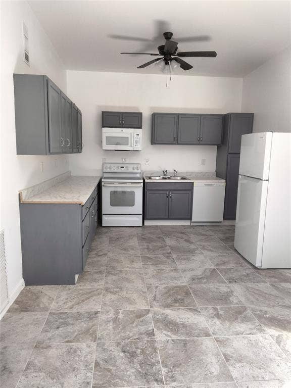 Kitchen featuring gray cabinetry, stone-finish countertops, tile flooring, integrated ceiling fan, and built-in appliances