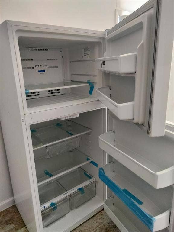 Top-mount refrigerator featuring a white finish, adjustable shelving, integrated door storage bins, and clear crisper drawers