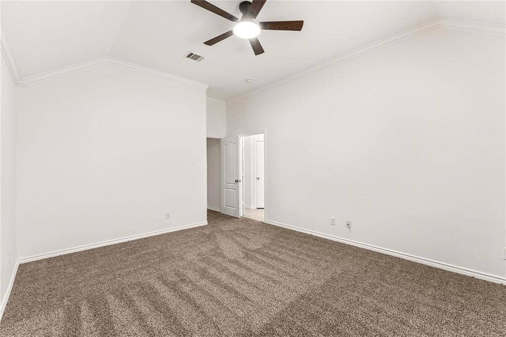 Vaulted ceilings, neutral wall tones, carpeted flooring, and an integrated ceiling fan with light fixture
