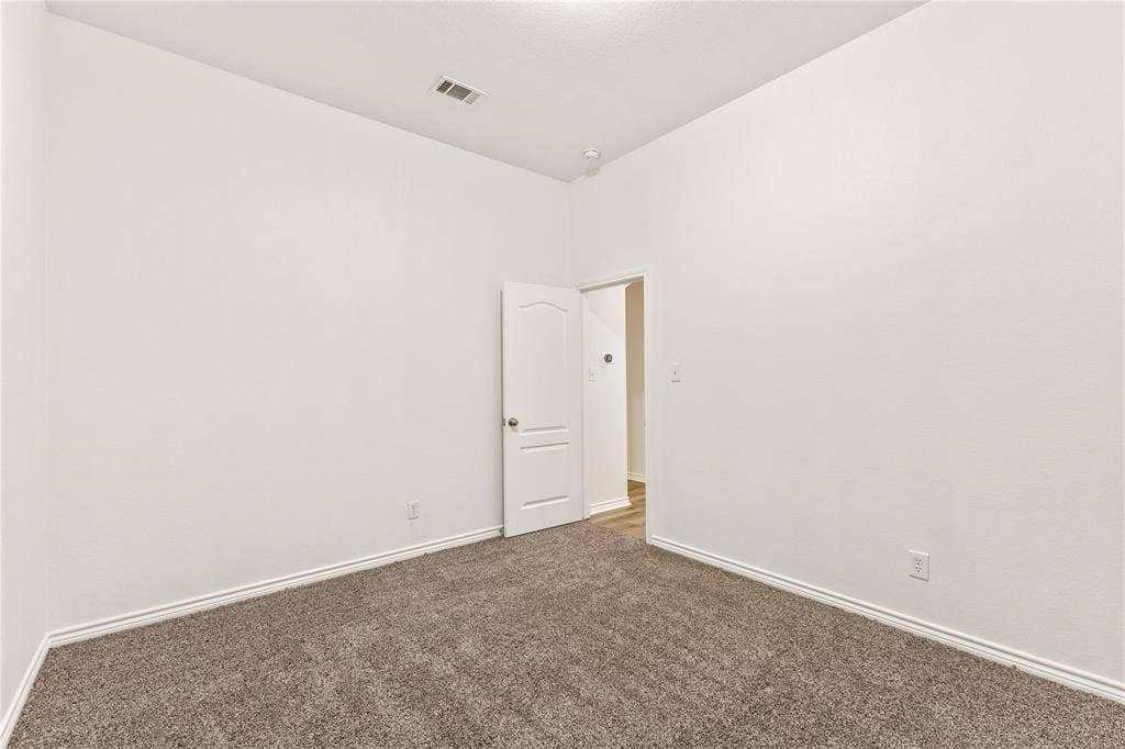 Interior room featuring neutral wall paint, carpeted flooring, and a single-panel interior door